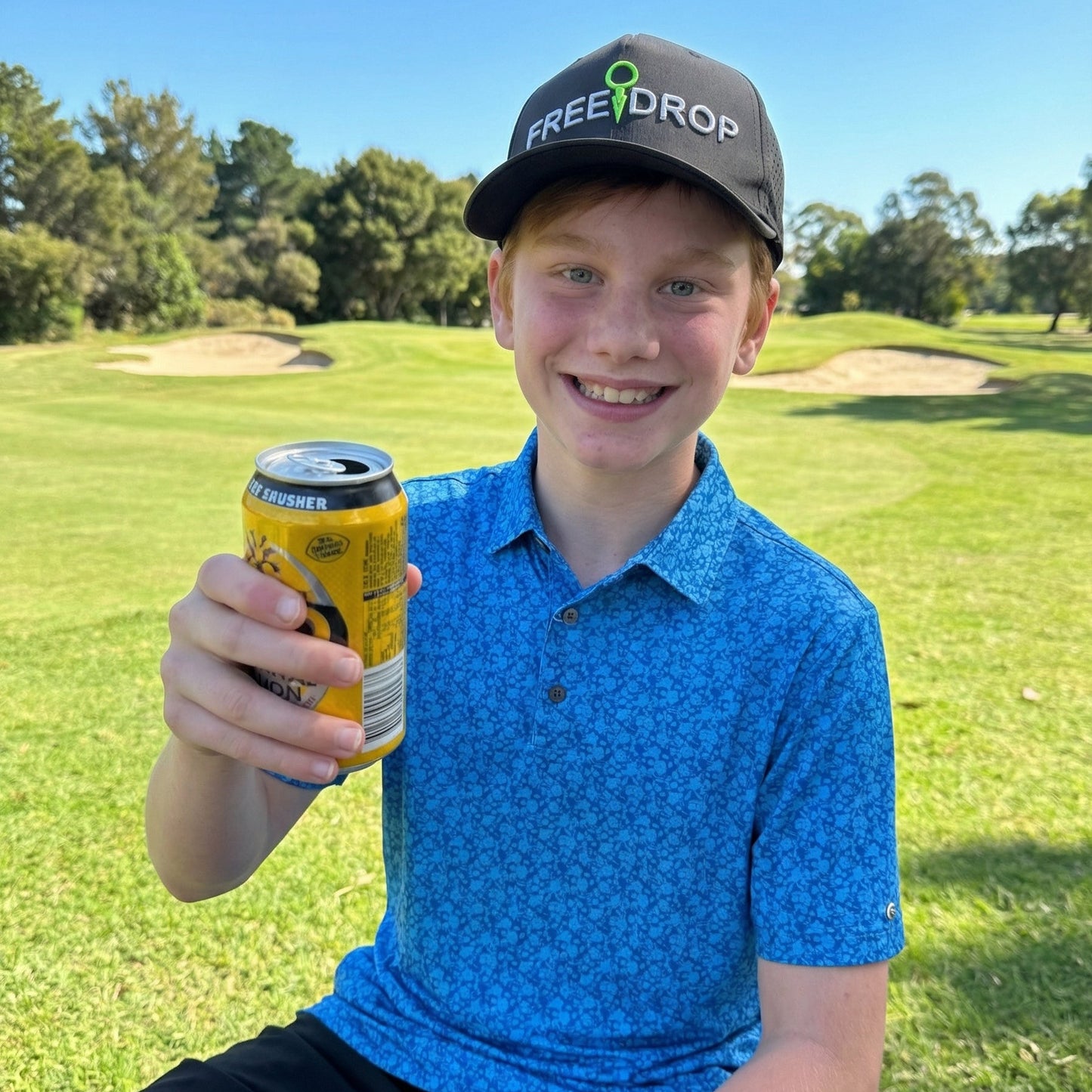 Young boy holding a can on a golf course