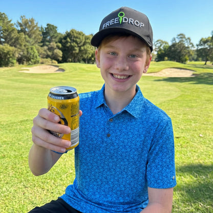 Young boy holding a can on a golf course